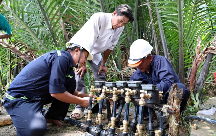 Nhân viên Xí nghiệp Cấp nước Cần Giờ lắp đặt hệ thống đồng hồ nước mới cho các hộ dân.